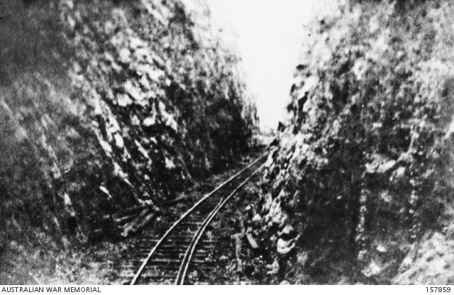 Railway tracks between rock walls.