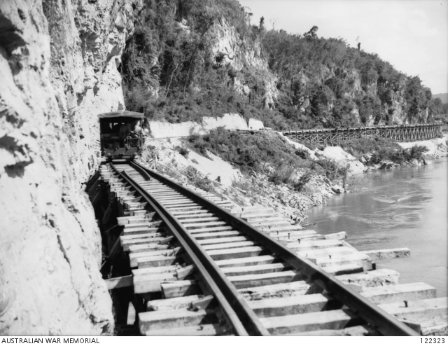 A diesel rail car passing over the long trestle bridge.